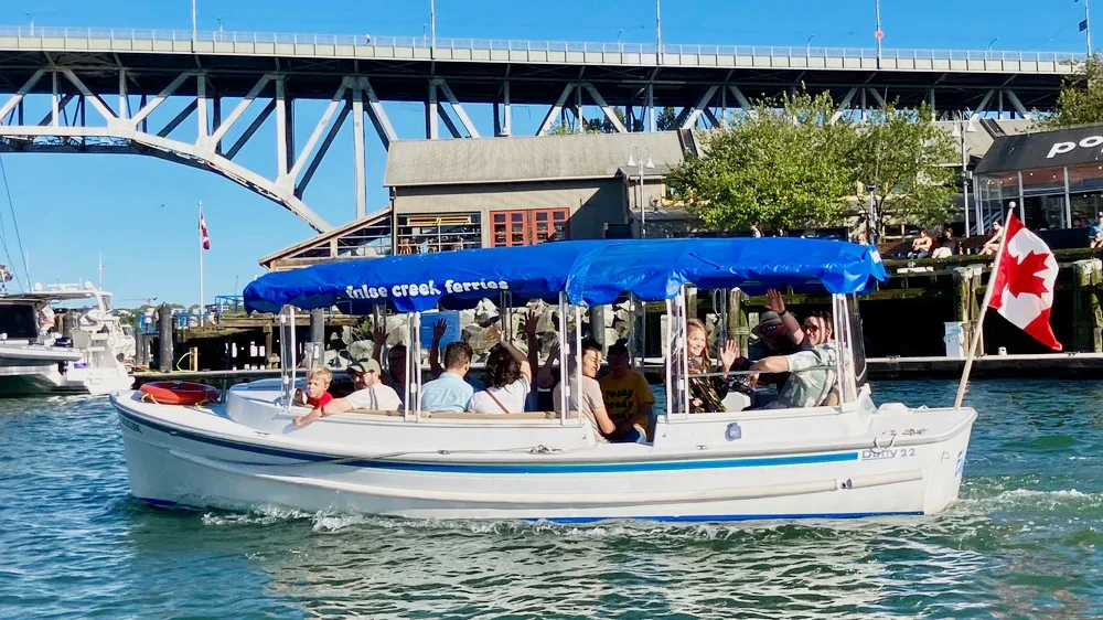 a covered electric tour boat operated by false creek ferries